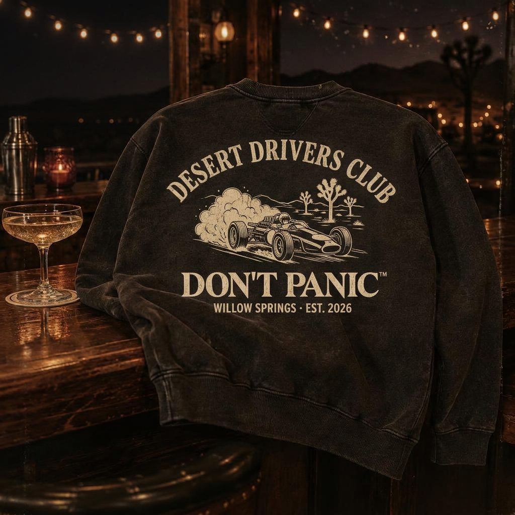 Washed black crewneck printed Desert Drivers Club on a bar top at night