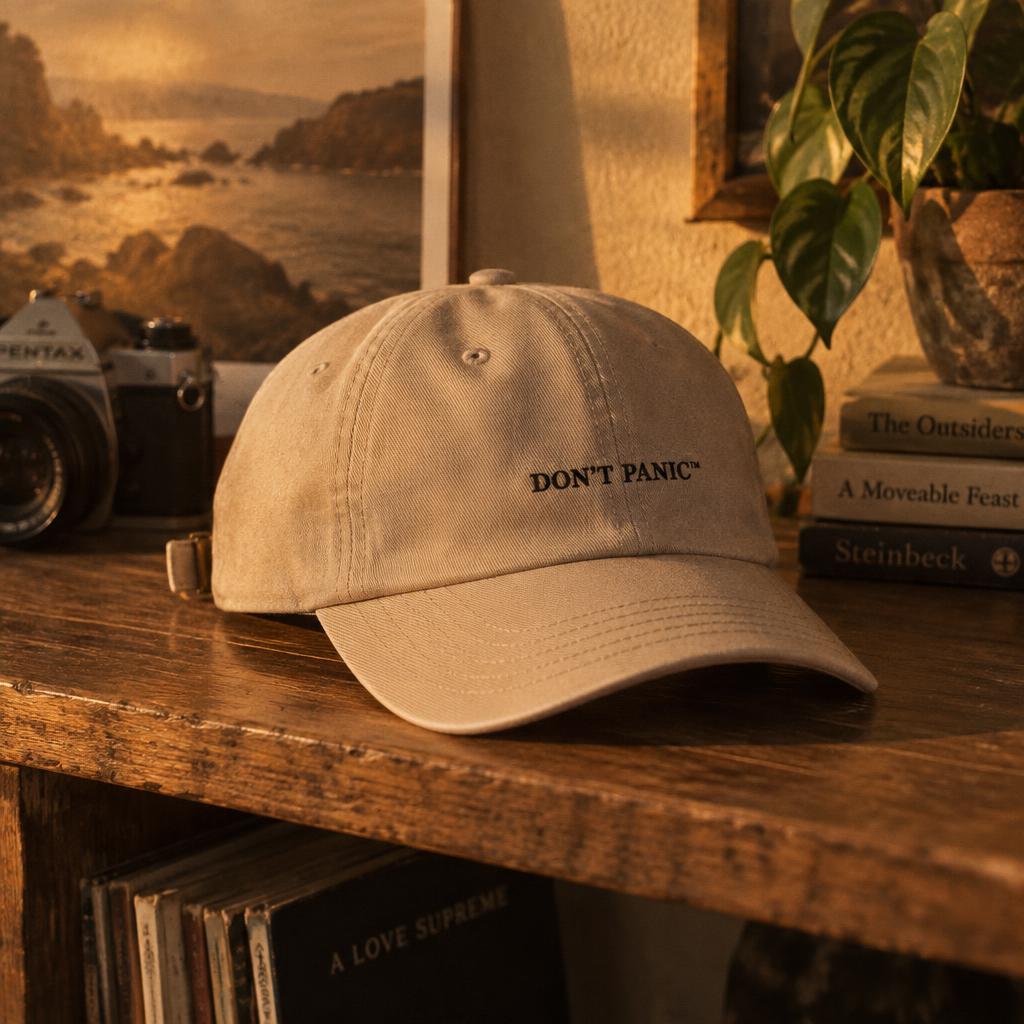 Sand washed-twill cap with the DON'T PANIC wordmark stitched on the front